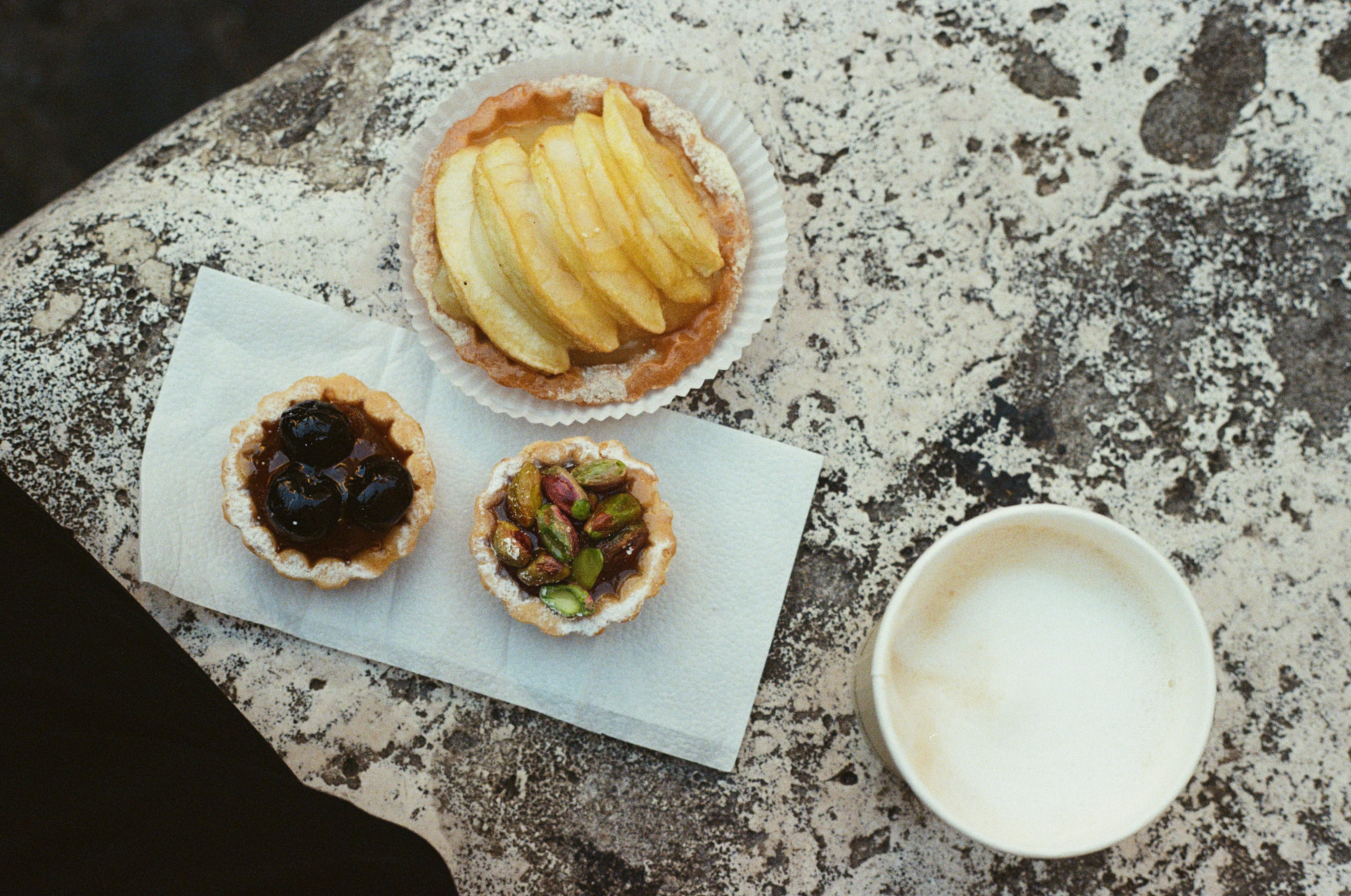 Pastries and coffee sitting on a ledge in front of a fountain in Rome, Italy